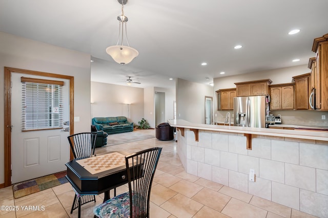 9307 Torrey Pines Ln, Yakima, WA 98908 - kitchen with stainless steel appliances, light countertops, brown cabinets, open floor plan, and recessed lighting