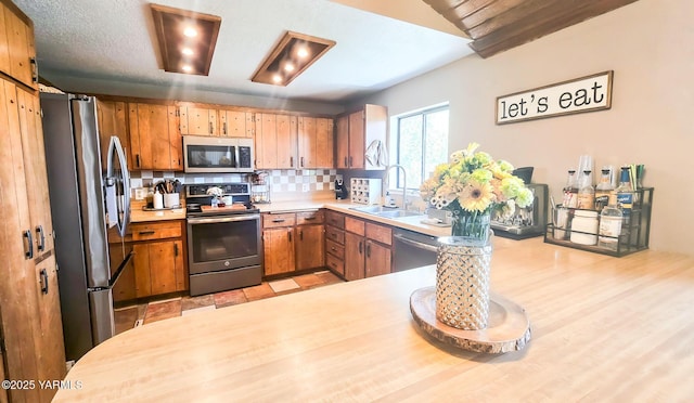 1391 Lancaster Rd, Selah, WA 98942 - kitchen with appliances with stainless steel finishes, light countertops, tasteful backsplash, and brown cabinetry