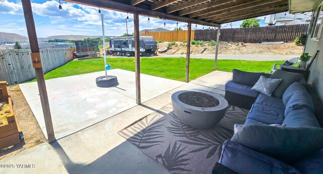 1391 Lancaster Rd, Selah, WA 98942 - fenced backyard with a trampoline, a patio area, an outdoor living space with a fire pit, and a mountain view