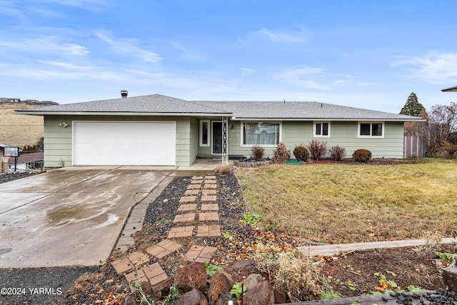 ranch-style home with an attached garage, a shingled roof, a front lawn, and concrete driveway