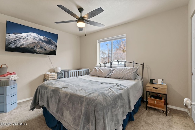 bedroom with a ceiling fan, light carpet, and baseboards