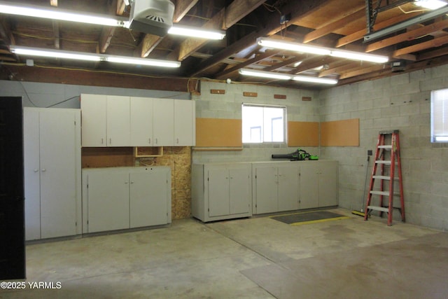 garage featuring a garage door opener and concrete block wall