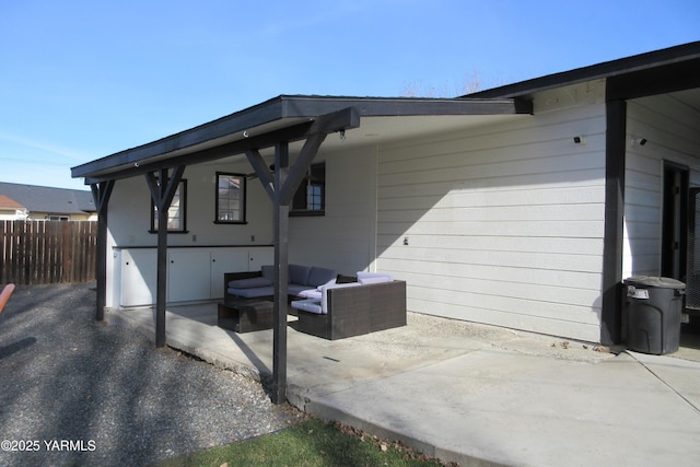 view of side of property featuring a patio area, fence, and an outdoor hangout area