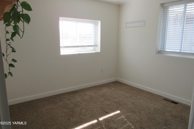 carpeted spare room with visible vents and baseboards