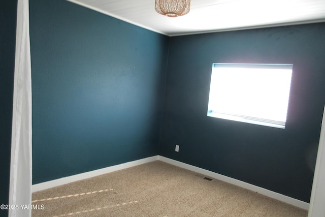 unfurnished room with baseboards, carpet floors, and visible vents