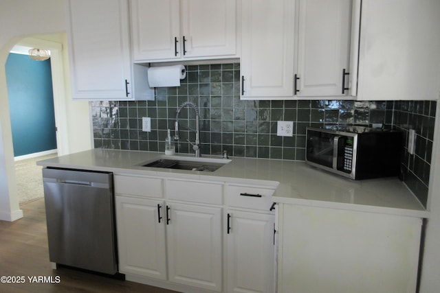 kitchen with a sink, stainless steel appliances, light countertops, and white cabinetry