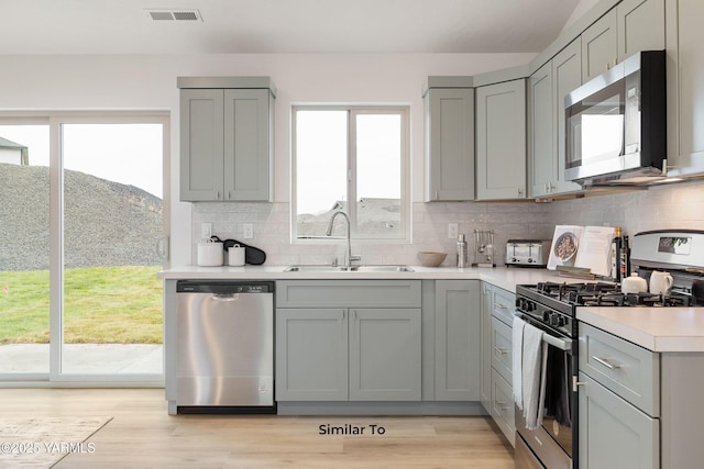 703 Vineyard Street (Phase 2Lot 21) Spec, Grandview, WA 98930 - kitchen featuring stainless steel appliances, gray cabinetry, a sink, and tasteful backsplash