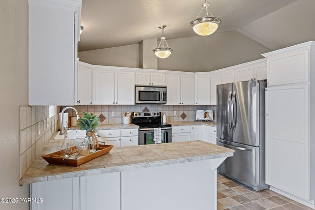 kitchen with a sink, tasteful backsplash, appliances with stainless steel finishes, a peninsula, and vaulted ceiling