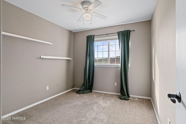 carpeted empty room featuring baseboards and ceiling fan