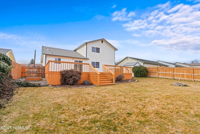 rear view of house with a deck, a yard, and a fenced backyard