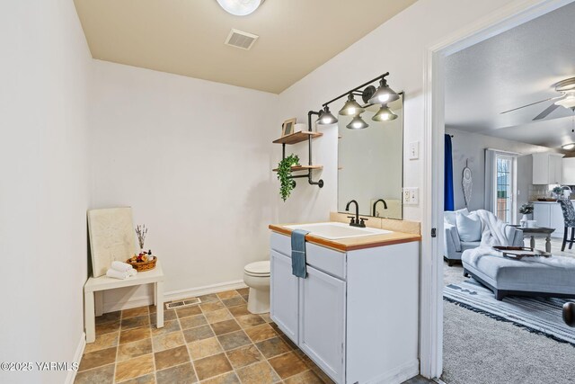 ensuite bathroom featuring visible vents, toilet, a ceiling fan, ensuite bath, and vanity