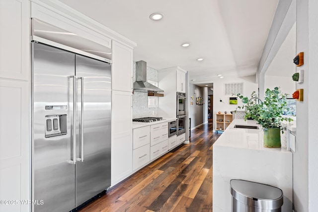 5709 Marilane St, Yakima, WA 98908 - kitchen featuring appliances with stainless steel finishes, wall chimney exhaust hood, recessed lighting, light countertops, and white cabinets