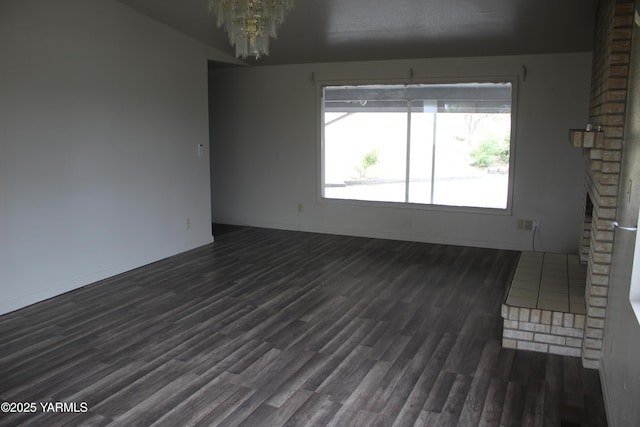 319 NW Crescent Ave, Sunnyside, WA 98944 - empty room with a chandelier, dark wood-type flooring, and baseboards