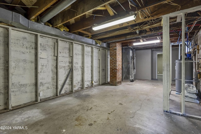 unfinished basement with strapped water heater and heating unit