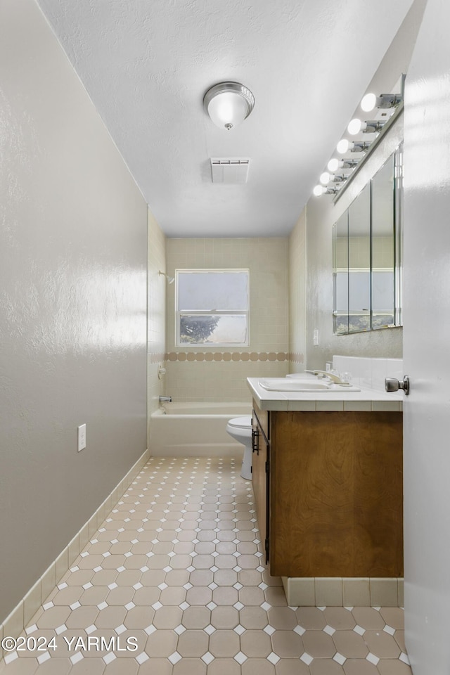 bathroom with visible vents, toilet, a washtub, a textured ceiling, and vanity