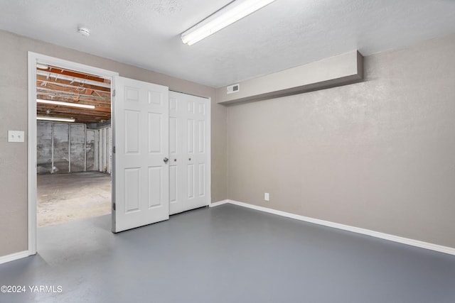 unfurnished bedroom with concrete floors, a closet, visible vents, and baseboards