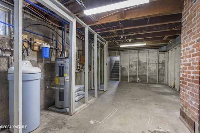 unfinished basement with stairs and water heater