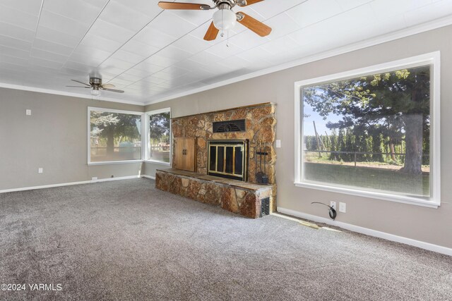 unfurnished living room with crown molding, a fireplace, baseboards, and carpet flooring
