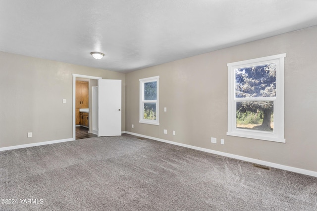 carpeted empty room with visible vents and baseboards