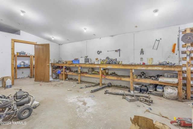 miscellaneous room featuring vaulted ceiling and a workshop area