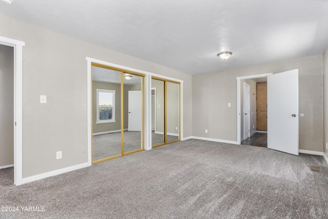 carpeted empty room featuring baseboards