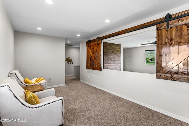 sitting room with a barn door, visible vents, baseboards, carpet, and recessed lighting