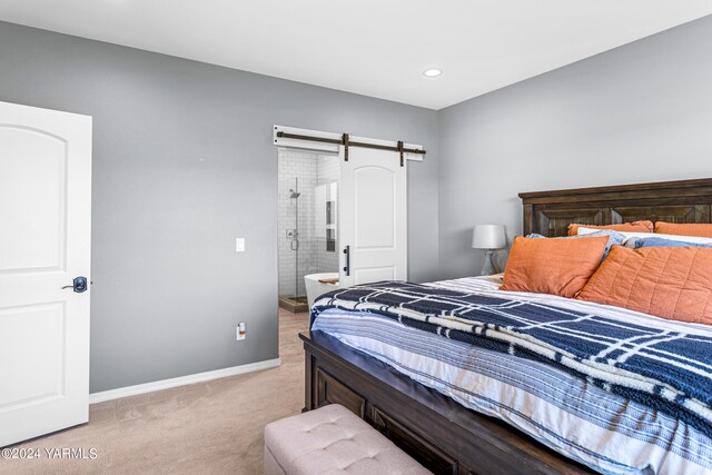 bedroom with a barn door, baseboards, light colored carpet, ensuite bathroom, and recessed lighting