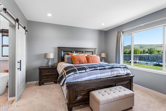 bedroom with recessed lighting, a barn door, light carpet, a mountain view, and baseboards