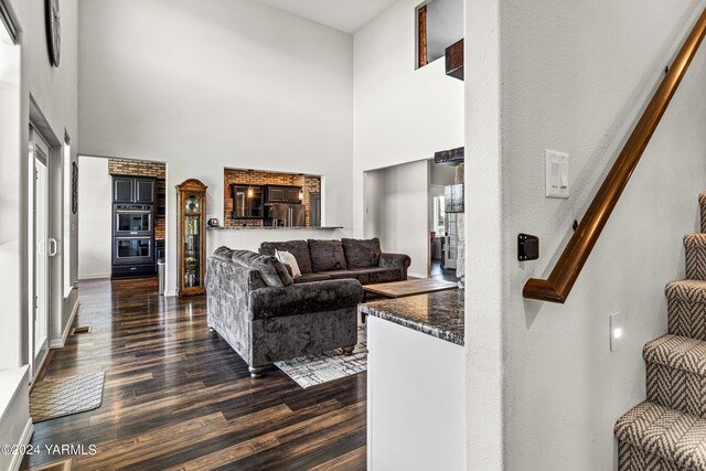 living area with visible vents, dark wood finished floors, and a high ceiling