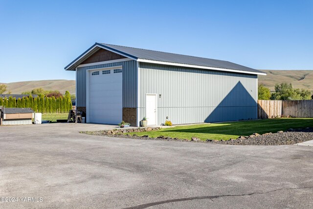 view of outbuilding featuring a mountain view, an outdoor structure, and fence