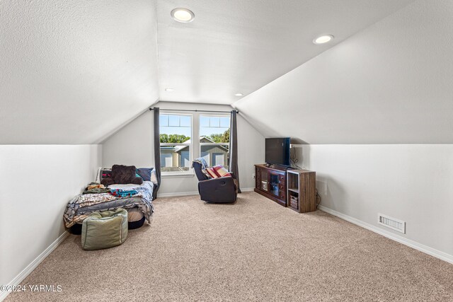 bedroom with carpet floors, baseboards, vaulted ceiling, and a textured ceiling