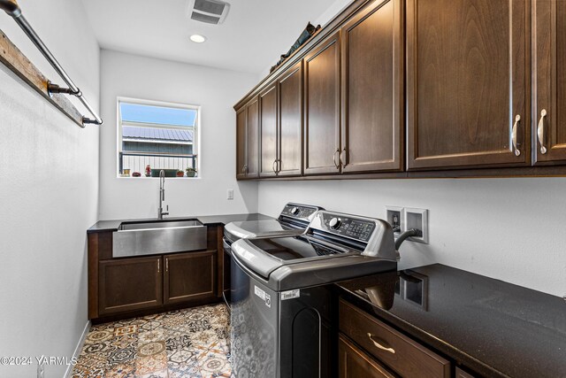 washroom with light tile patterned floors, cabinet space, visible vents, washing machine and dryer, and a sink