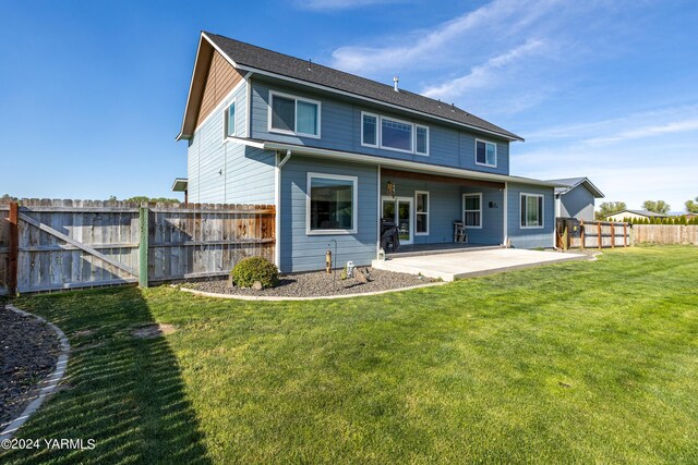 rear view of property with a patio, a lawn, and a fenced backyard