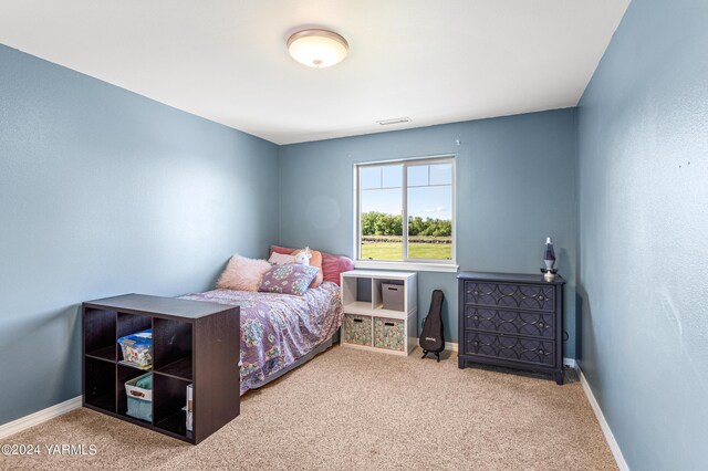 bedroom featuring light carpet, visible vents, and baseboards