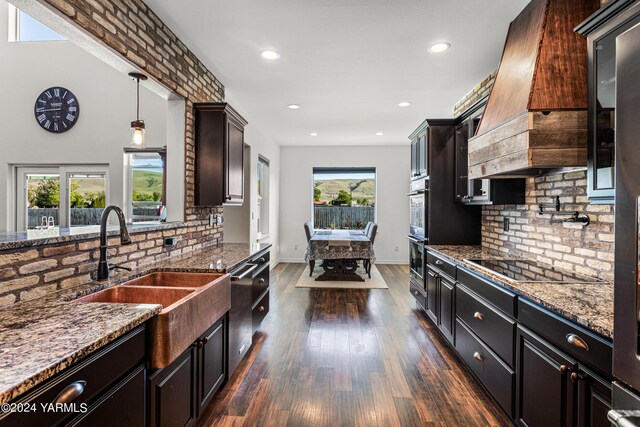 kitchen featuring stainless steel appliances, stone countertops, pendant lighting, and dark wood-style flooring