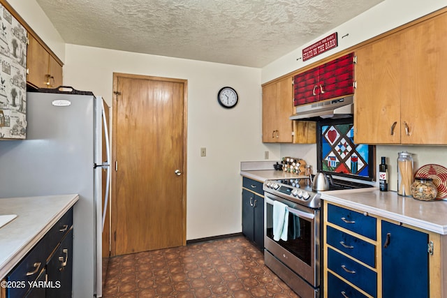 kitchen with brown cabinetry, stainless steel appliances, a textured ceiling, light countertops, and under cabinet range hood