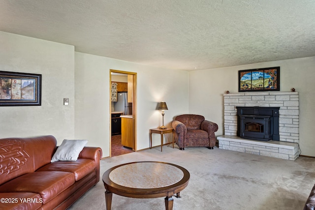 carpeted living room featuring a textured ceiling and a stone fireplace