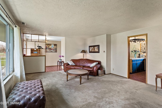 carpeted living area featuring visible vents and a textured ceiling