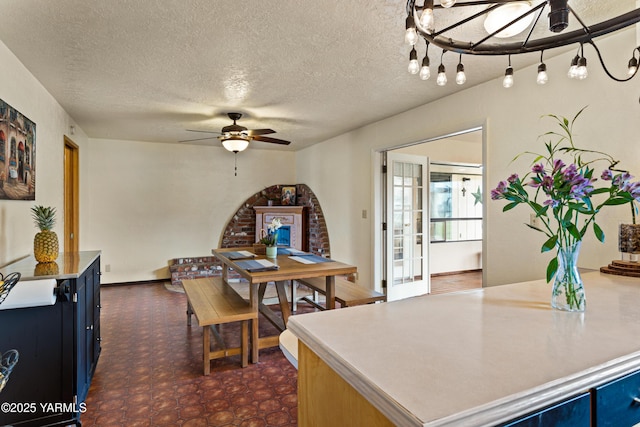 dining area featuring a textured ceiling, a ceiling fan, and dark floors