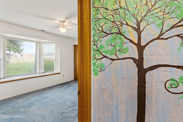 interior space with a ceiling fan and carpet flooring