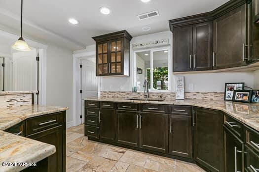 921 Tibbling Rd, Selah, WA 98942 - kitchen featuring a sink, light stone countertops, stone tile floors, recessed lighting, and decorative light fixtures