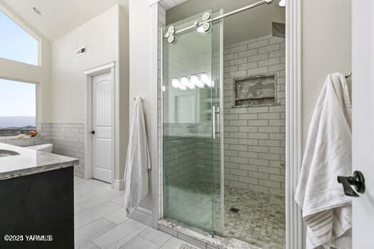 921 Tibbling Rd, Selah, WA 98942 - bathroom with vanity, a shower stall, tile walls, tile patterned flooring, and wainscoting