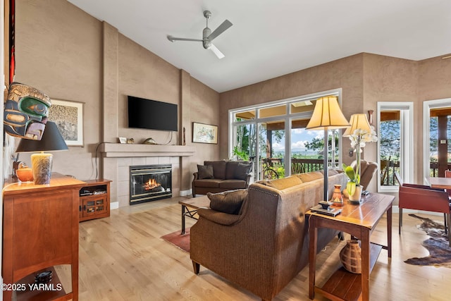 131 Katie Ln, Selah, WA 98942 - living room with high vaulted ceiling, a ceiling fan, light wood finished floors, and a tile fireplace