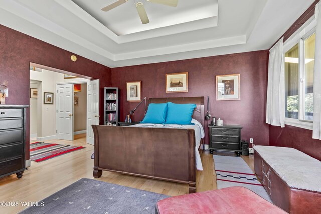 131 Katie Ln, Selah, WA 98942 - bedroom featuring a tray ceiling, wood finished floors, ceiling fan, and baseboards