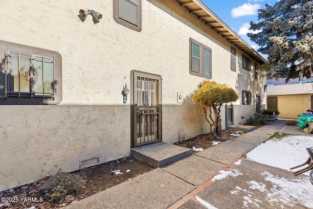 view of exterior entry featuring stucco siding