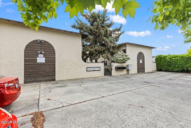 view of side of property featuring a gate and stucco siding