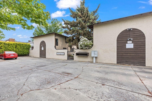 view of property exterior featuring fence, a gate, and stucco siding