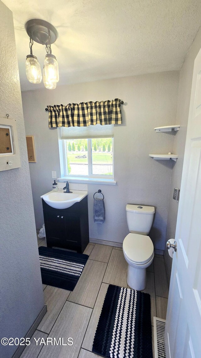 15911 Fisk Rd, Yakima, WA 98908 - half bathroom featuring wood finish floors, toilet, and vanity