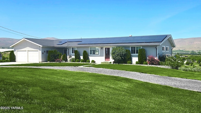 15911 Fisk Rd, Yakima, WA 98908 - ranch-style house with a front lawn, solar panels, an attached garage, concrete driveway, and a mountain view