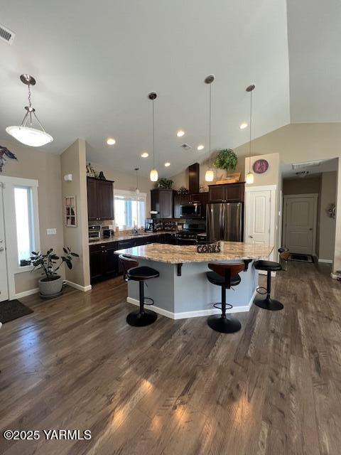 522 Adobe Way, Selah, WA 98942 - kitchen with stainless steel appliances, a breakfast bar area, a spacious island, dark brown cabinetry, and vaulted ceiling